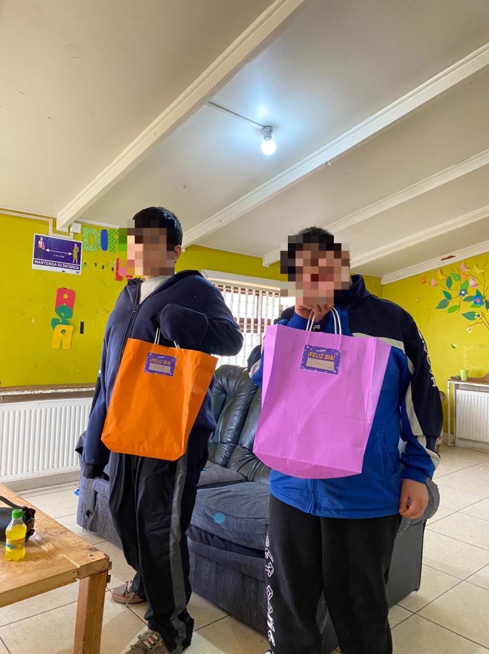 Niños en una sala de estar, posando con sus nuevos regalos del día del niño